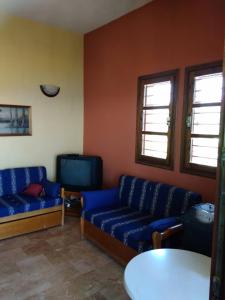 a living room with two blue couches and a table at Best view in Polychrono - Families Only in Polychrono