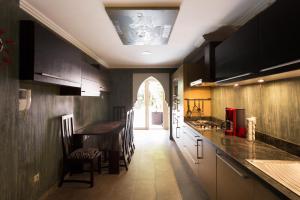 a kitchen with a counter and a table and chairs at The Sapphire Apartment with Private Swimming Pool & Hot Tub - Hivernage Quarter - By Goldex Marrakech in Marrakech