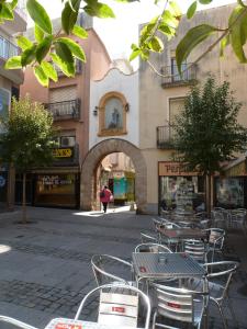 a group of tables and chairs in front of a building at Hotel Costa Brava in Blanes