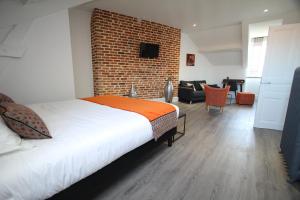 a bedroom with a bed and a brick wall at Le clos des etoiles in Paray-le-Monial