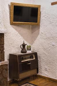 a television on a table with a vase on top of it at Koukos Rhodian Guesthouse - Adults Only in Rhodes Town