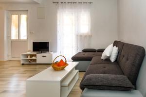 a living room with a couch and a tv at Apartman Dobrila in Vrh