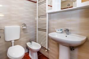 a bathroom with a white toilet and a sink at Apartman Dobrila in Vrh +16 photos