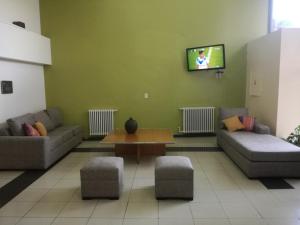 una sala de espera con sofás, mesa y TV en Hotel Puerta del Sol, en Mendoza