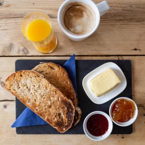 a black plate with bread and butter and a cup of coffee at Five Bells Inn, Wrentham in Wrentham