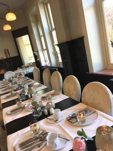 a row of tables in a room with chairs at Charmehotel Villa Saporis in Hasselt