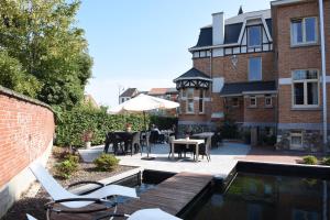 a patio with a table and chairs next to a building at Charmehotel Villa Saporis in Hasselt