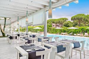 a restaurant with tables and chairs and a swimming pool at Italiana Hotels Florence in Florence