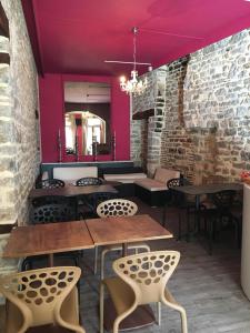 a room with tables and chairs and a brick wall at Hôtel du Commerce in Semur-en-Auxois