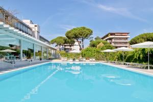 a large swimming pool with chairs and umbrellas at Italiana Hotels Florence in Florence