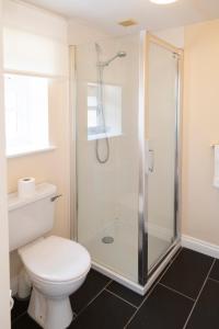 uma casa de banho com um WC e um chuveiro em Five Bells Inn, Wrentham em Wrentham
