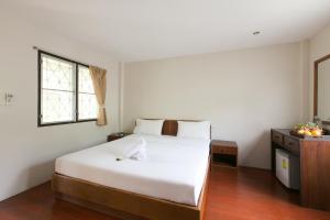 1 dormitorio con cama blanca y ventana en Thongtakian Resort, en Lamai