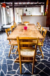 - une table en bois avec des chaises et un bol rose dans l'établissement La Retirée, à Grimbiémont