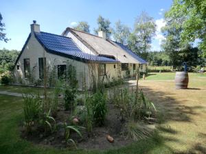 an old house with a blue roof and a garden at de Kruik in Blesdijke