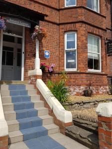 ein Backsteingebäude mit einer Treppe vor einem Gebäude in der Unterkunft Autumn Leaves Guest House in Whitby