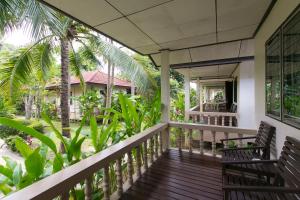 a balcony of a house with chairs and palm trees at Thongtakian Resort in Lamai