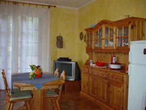 a kitchen with a table and a microwave and a refrigerator at Villetta a 300mt dal mare Cala Sinzias in Cala Sinzias