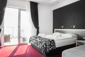 佩特罗瓦纳莫鲁Vile Oliva Hotel & Resort的一间带大床和大窗户的卧室