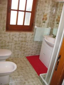 a bathroom with a toilet and a sink and a window at Villetta a 300mt dal mare Cala Sinzias in Cala Sinzias