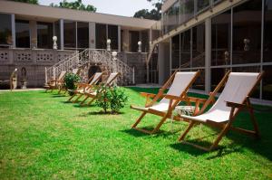 a row of chairs sitting in the grass in front of a building at Castelo Santa Catarina in Porto