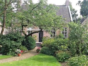 una casa de ladrillo con un jardín de plantas en De Oude Pastorie, en Netersel