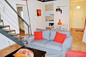 コスタ・ダ・カパリカにあるAroeira Golf&Beachのリビングルーム(赤い枕と青いソファ付)