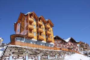 budynek z drewnianymi balkonami na szczycie góry w obiekcie Hotel Residence Dahu w mieście Passo del Tonale