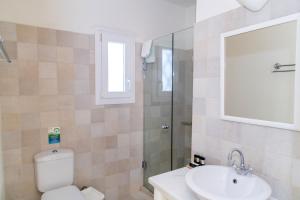 a bathroom with a toilet and a sink and a mirror at Anthea Hotel in Tinos Town