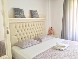 a bedroom with a bed with a white headboard at Sweet Rooms Kavala in Kavála