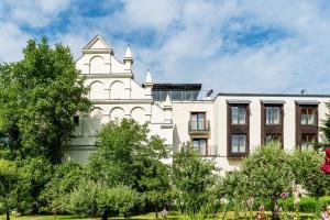 a white building with a tower on top of it at Hotel Król Kazimierz in Kazimierz Dolny