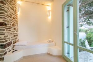 einen Fensterplatz in einem Zimmer mit Ziegelwand in der Unterkunft Anthea Hotel in Tinos