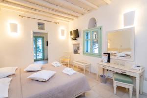 ein Zimmer mit einem Bett, einem Schreibtisch und einem Spiegel in der Unterkunft Anthea Hotel in Tinos + 178 Fotos