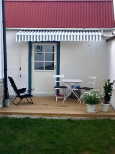 d'une terrasse avec des chaises, une table et une porte. dans l'établissement Karl-Oskars Krypin, à Visby