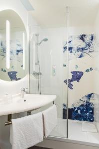 La salle de bains est pourvue d'une douche et d'un lavabo. dans l'établissement ibis budget Paris Porte de Bercy, à Charenton-le-Pont