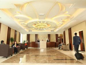 a man walking down a hallway in a hotel lobby at Best Western Plus Salmiya in Kuwait