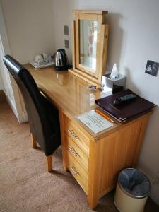a wooden desk with a chair and a mirror at St Ann’s Guest House in Inverness +9 photos