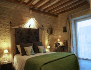 ein Schlafzimmer mit einem großen Bett und einer grünen Decke in der Unterkunft B&B Les Oiseaux de Passage in Isigny-sur-Mer
