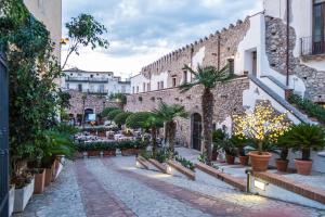 an alley with potted plants in front of a building at Hotel Residence La Fortezza in San Lucido