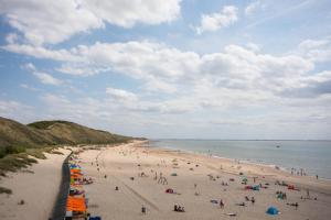 a group of people on a beach with the ocean at Duinhotel Tien Torens in Zoutelande