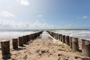 a pier stretches out into the ocean on a beach at Duinhotel Tien Torens in Zoutelande