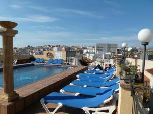 a row of lounge chairs on the roof of a building at Hotel Costa Brava in Blanes