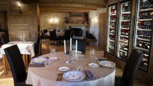 Le Tillau في Les Verrières-de-Joux: طاولة مع أطباق وأكواب النبيذ في المطعم