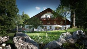 une grande maison avec des rochers devant elle dans l'établissement Le Tillau, à Les Verrières-de-Joux