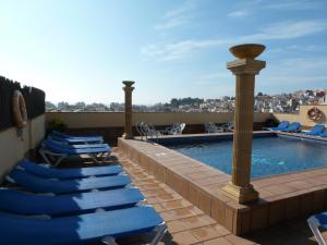 a swimming pool with blue lounge chairs on a roof at Hotel Costa Brava in Blanes