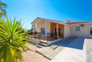 a house with a palm tree in front of it at Villa Chrystalla in Neo Chorio