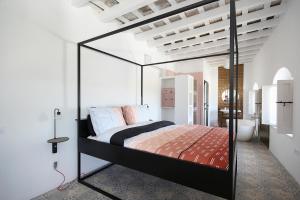 een slaapkamer met een bed met een glazen baldakijn bij Casa Bonhomía in Vejer de la Frontera