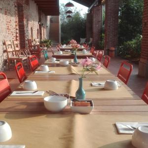 una larga mesa de madera con sillas y un jarrón con flores en Agriturismo Tetto Garrone, en Cuneo