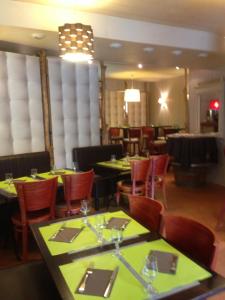 une salle à manger avec des tables et des chaises dans un restaurant dans l'établissement Hôtel La Tour D'Auvergne, à Pont-lʼAbbé