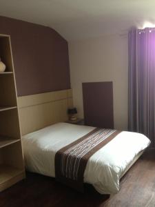 a bedroom with a bed and a book shelf at Hôtel La Tour D'Auvergne in Pont-lʼAbbé