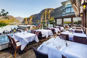 a restaurant with tables and chairs with mountains in the background at Seehotel Pilatus in Hergiswil